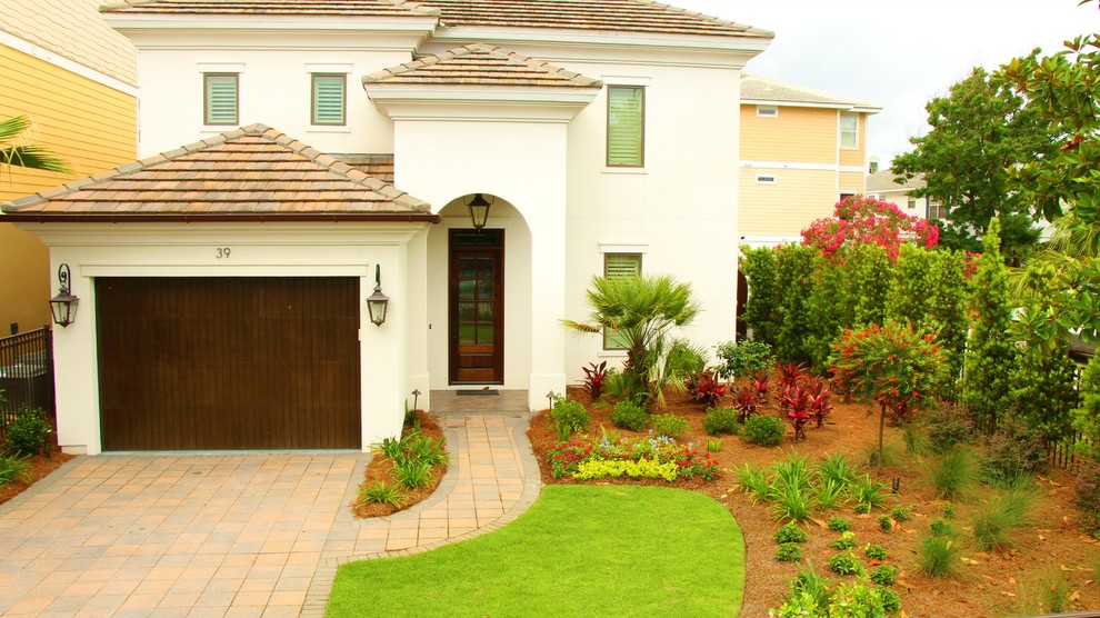 Inspiration for a large mediterranean front driveway full sun garden for summer in Jacksonville with brick paving.