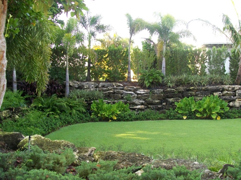 Design ideas for a mid-sized tropical partial sun backyard mulch landscaping in Miami for summer.