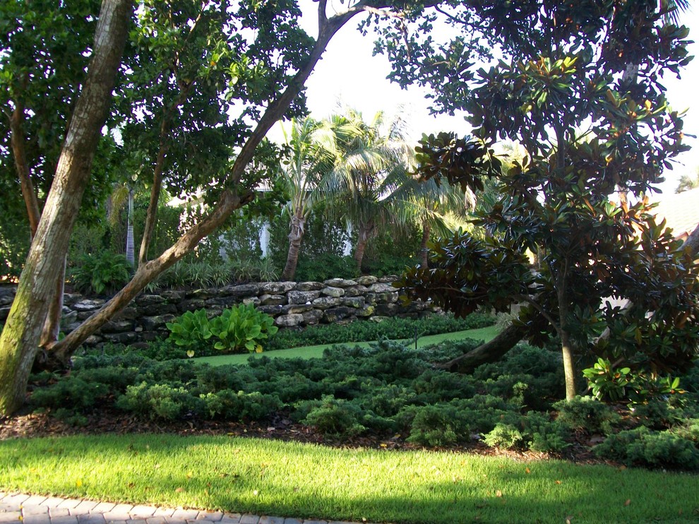 Design ideas for a mid-sized tropical partial sun backyard mulch landscaping in Miami for summer.