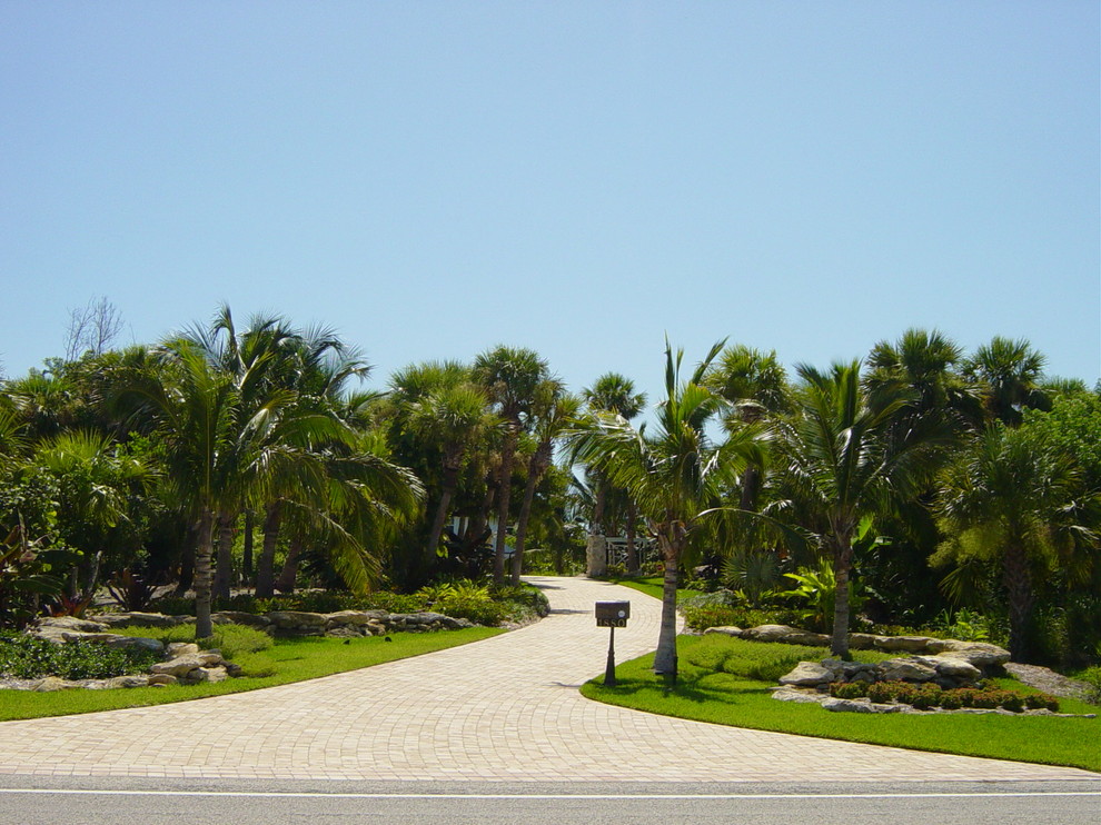 Immagine di un vialetto d'ingresso tropicale esposto a mezz'ombra di medie dimensioni e davanti casa in estate con un ingresso o sentiero e pavimentazioni in mattoni