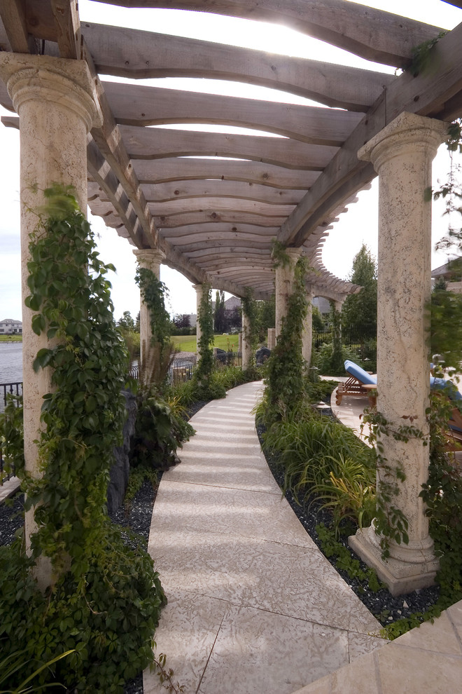 Exemple d'un très grand jardin arrière méditerranéen l'été avec une exposition ensoleillée et des pavés en béton.