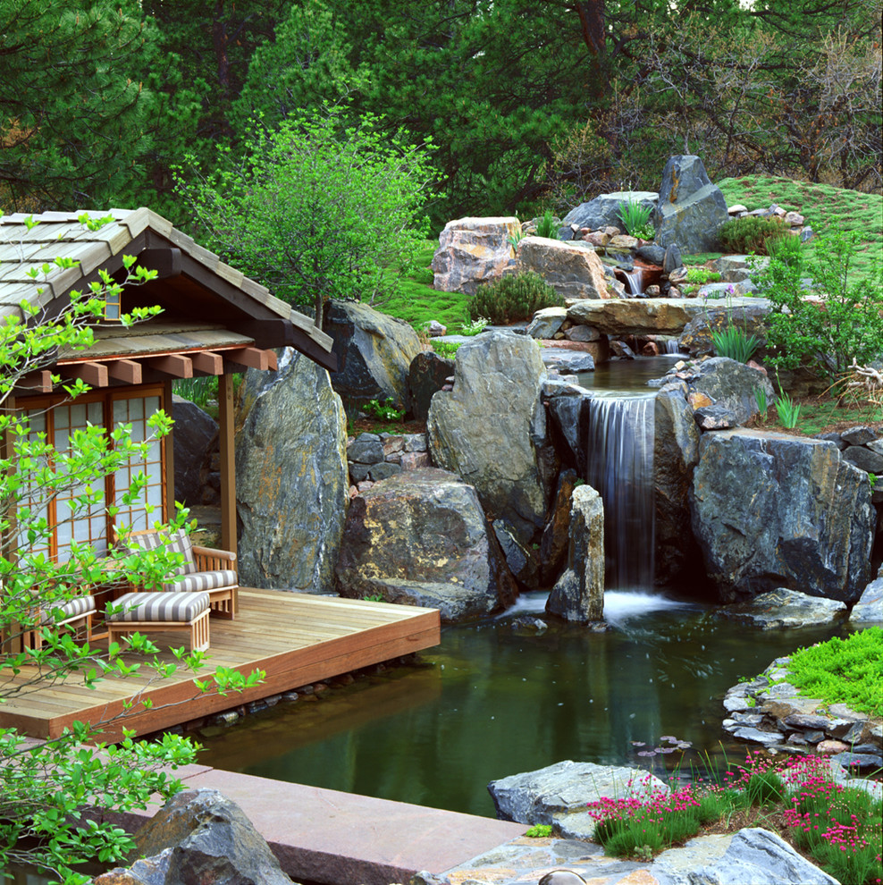 На фото: участок и сад в восточном стиле с настилом и водопадом