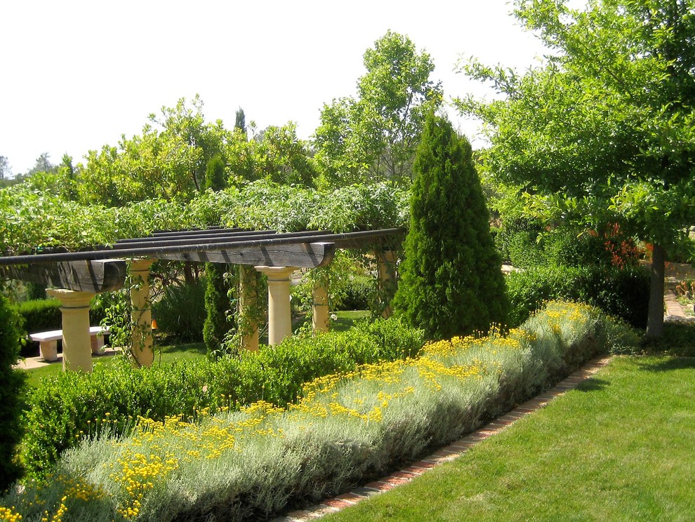 Esempio di un ampio giardino mediterraneo esposto in pieno sole in primavera con un pendio, una collina o una riva