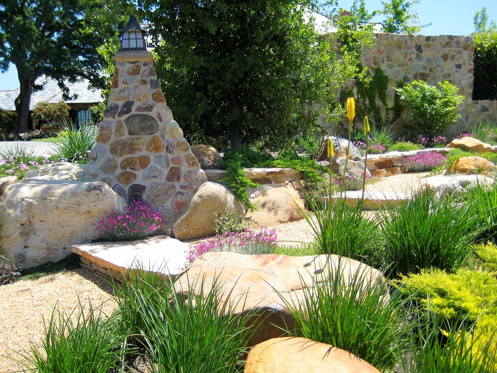 На фото: огромный солнечный, весенний участок и сад на боковом дворе в средиземноморском стиле с хорошей освещенностью, покрытием из каменной брусчатки и подпорной стенкой