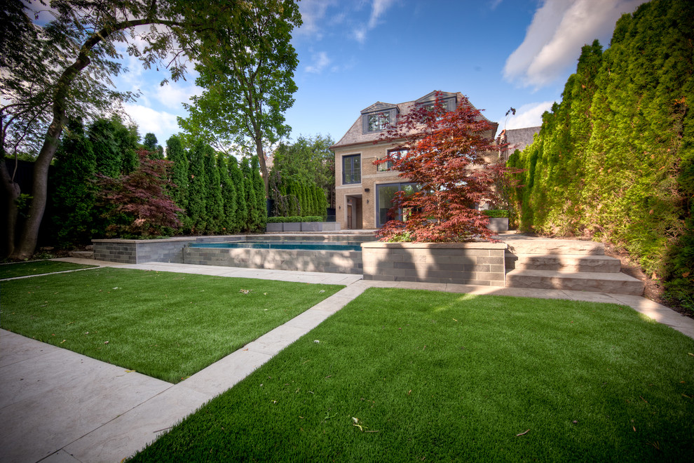 Photo of a mid-sized contemporary full sun backyard stone landscaping in Toronto for summer.