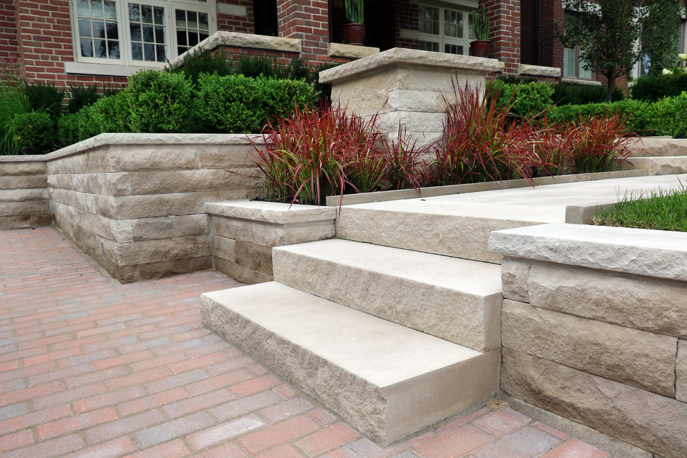 Inspiration for a mid-sized traditional front yard stone landscaping in Toronto.
