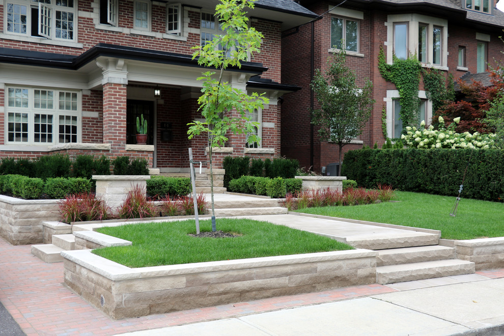 This is an example of a mid-sized traditional front yard stone landscaping in Toronto.
