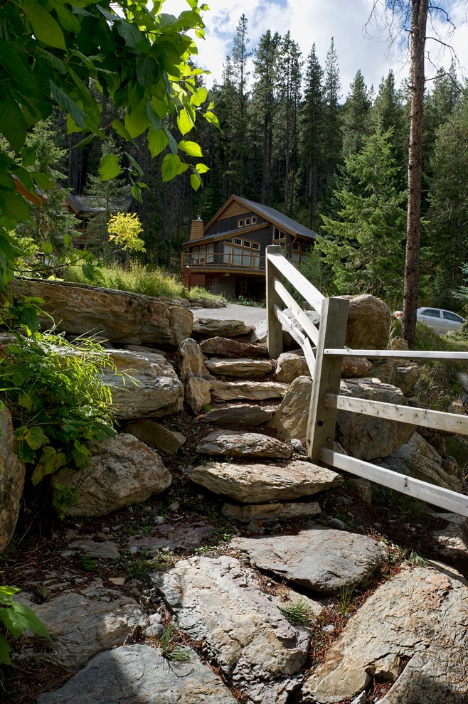 Design ideas for a rustic sloped garden in Calgary with natural stone paving.