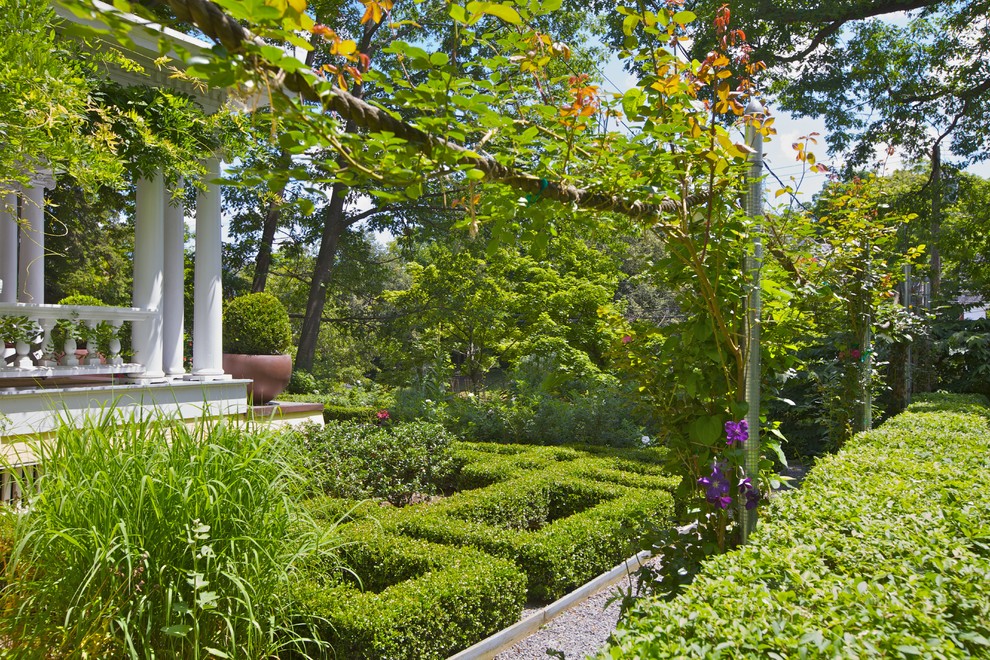 Immagine di un grande giardino formale classico esposto a mezz'ombra davanti casa con un ingresso o sentiero e ghiaia