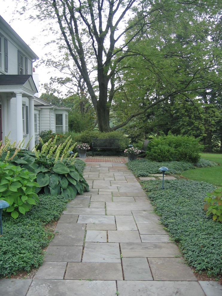 Idéer för att renovera en stor vintage trädgård i skuggan framför huset på sommaren, med en trädgårdsgång och naturstensplattor