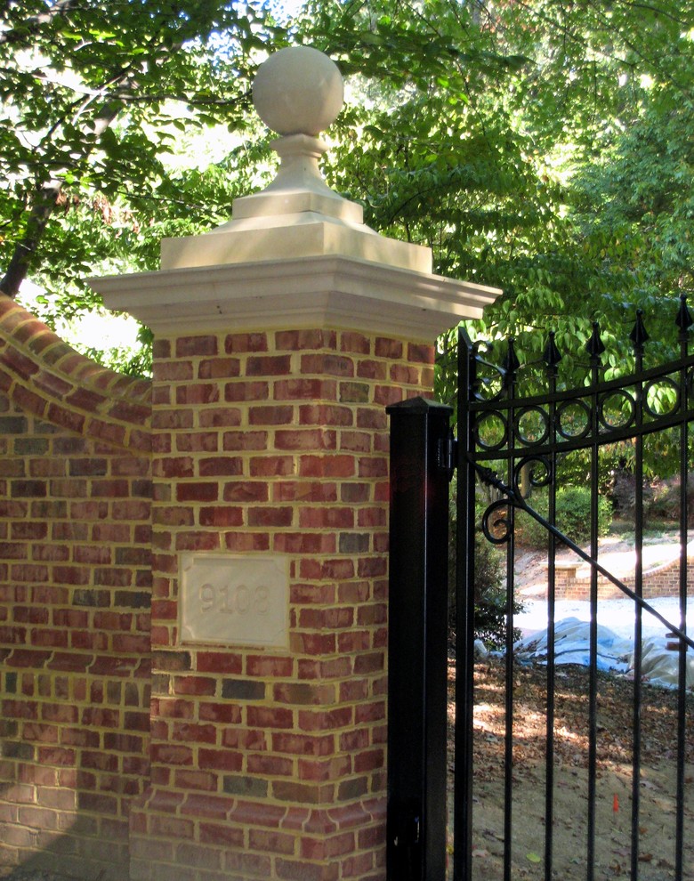 Photo of a large traditional front driveway partial sun garden in DC Metro with brick paving.