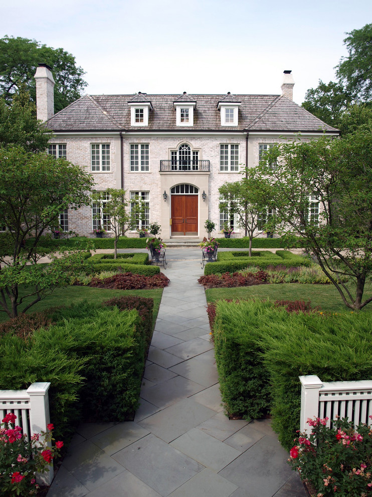 Immagine di un grande giardino formale tradizionale esposto in pieno sole davanti casa in estate con pavimentazioni in pietra naturale