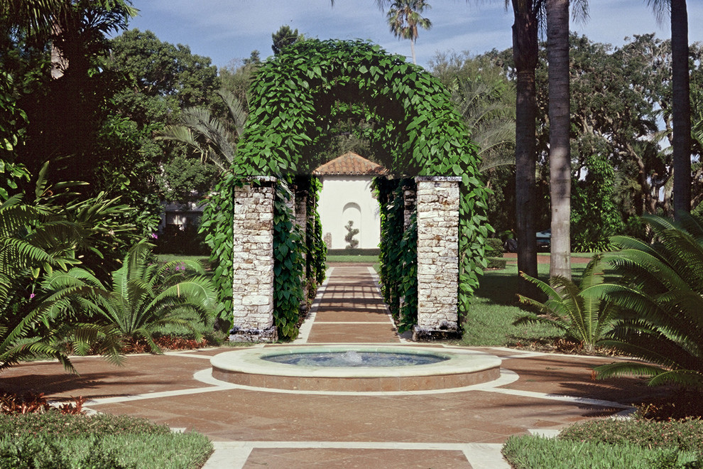 На фото: садовый фонтан на заднем дворе в средиземноморском стиле с