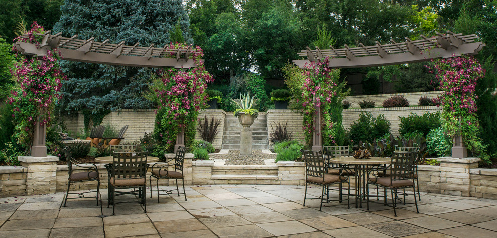 This is an example of a traditional back patio in Denver with natural stone paving.