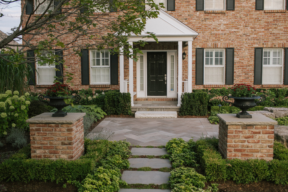 Esempio di un giardino formale chic esposto in pieno sole di medie dimensioni e davanti casa con un ingresso o sentiero e pavimentazioni in pietra naturale