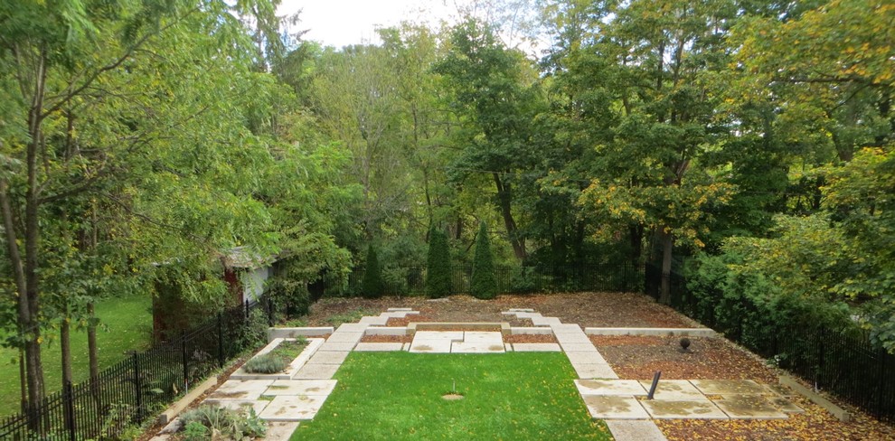 На фото: осенний регулярный сад на заднем дворе в классическом стиле с полуденной тенью и мощением тротуарной плиткой
