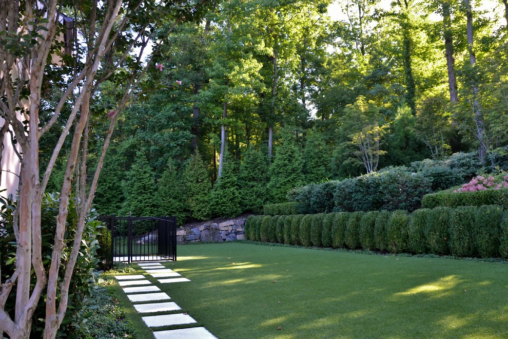 Ejemplo de jardín clásico extra grande en patio lateral con jardín francés y exposición parcial al sol