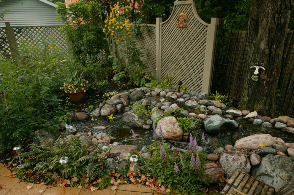 Mittelgroßer, Halbschattiger Klassischer Gartenteich im Sommer, hinter dem Haus mit Flusssteinen in Toronto