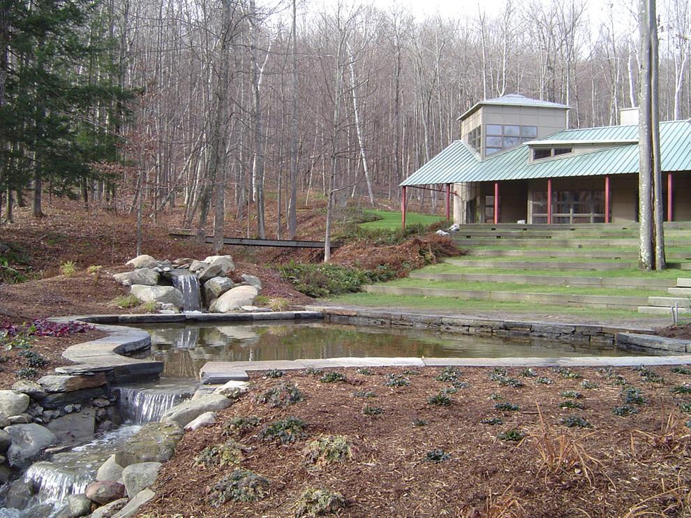 Idee per un grande laghetto da giardino design con un pendio, una collina o una riva e pavimentazioni in pietra naturale