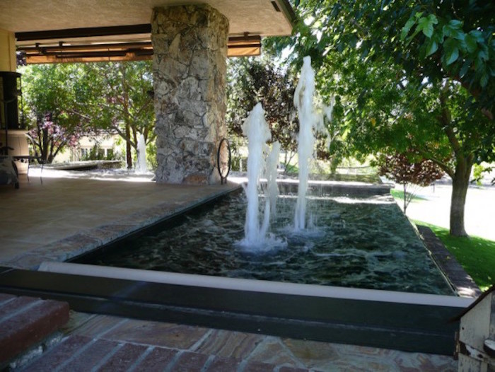 Esempio di un giardino tradizionale in ombra di medie dimensioni e dietro casa con fontane e pavimentazioni in mattoni