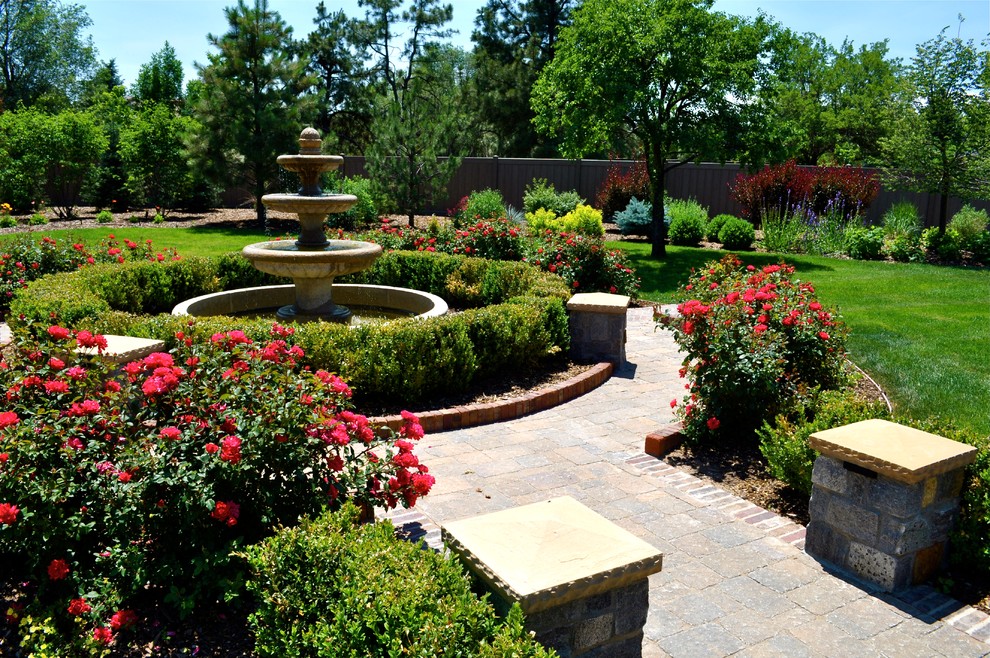 Foto de jardín clásico grande en patio trasero con jardín francés, fuente y adoquines de hormigón