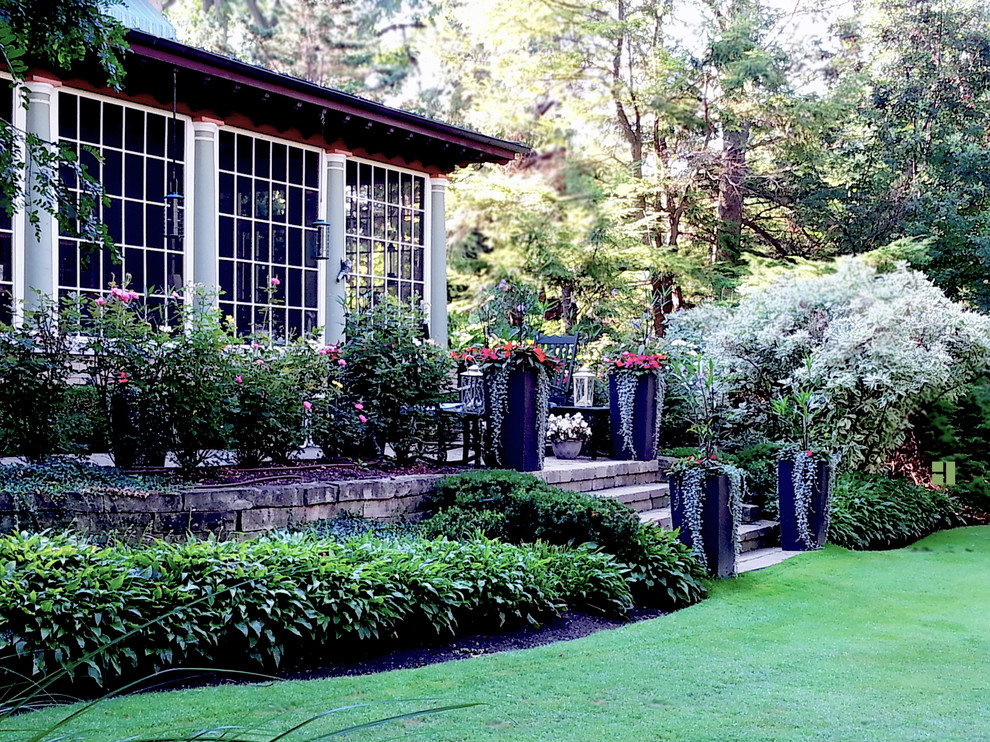 Inredning av en medelhavsstil mellanstor trädgård i skuggan på sommaren, med en trädgårdsgång och naturstensplattor