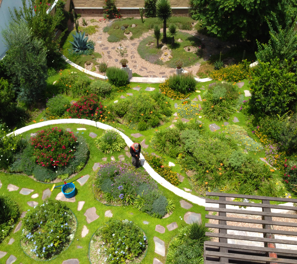 Exempel på en medelhavsstil trädgård, med en stödmur