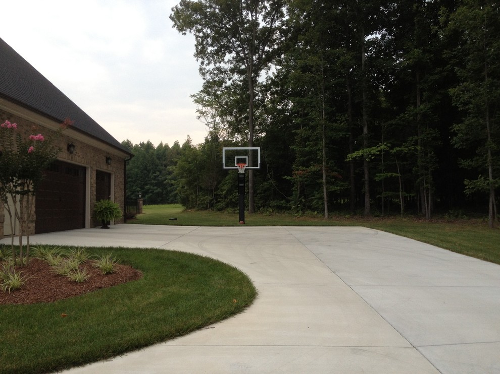 Photo of a large classic front partial sun garden in Raleigh with an outdoor sport court.