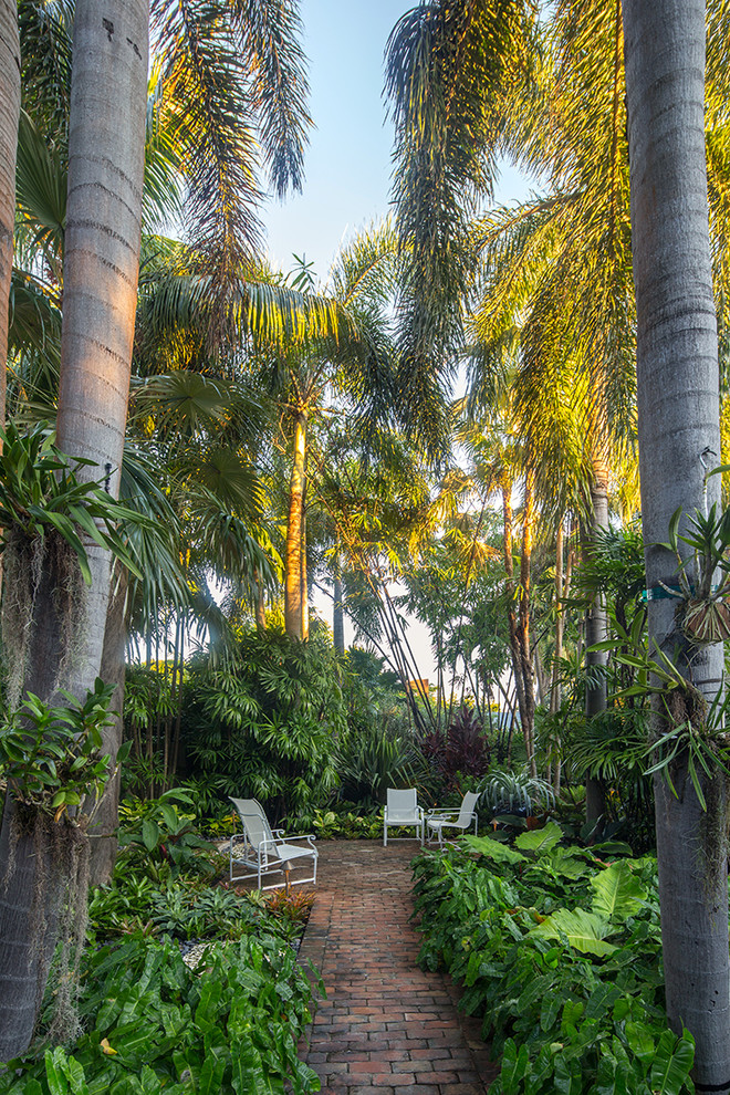 Foto de jardín exótico de tamaño medio en patio lateral con adoquines de ladrillo