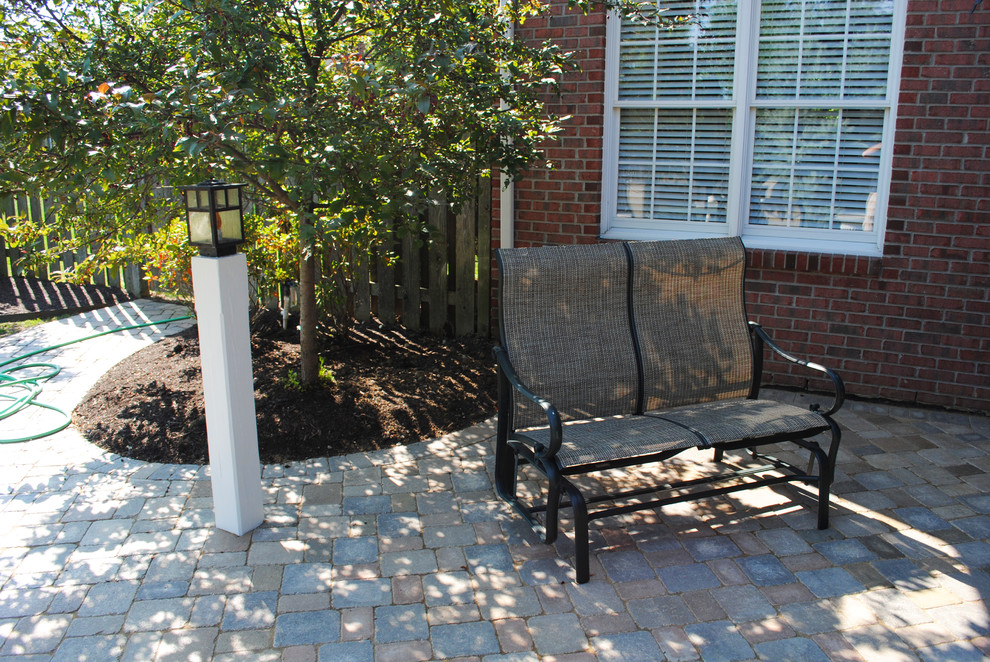 Modelo de jardín clásico de tamaño medio en patio trasero con exposición parcial al sol y adoquines de hormigón