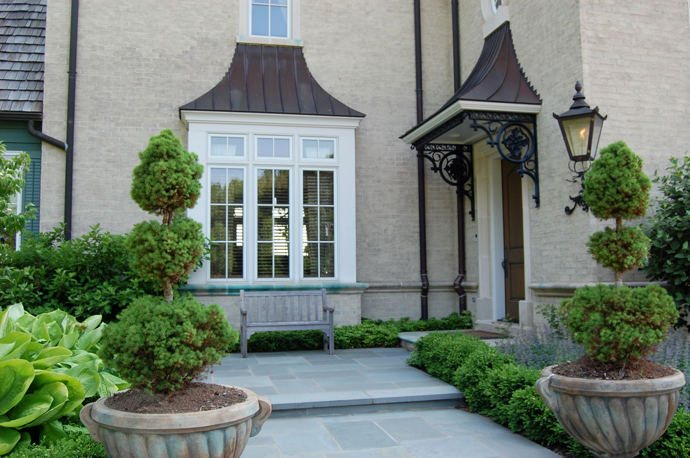 Пример оригинального дизайна: участок и сад на переднем дворе в классическом стиле с покрытием из каменной брусчатки