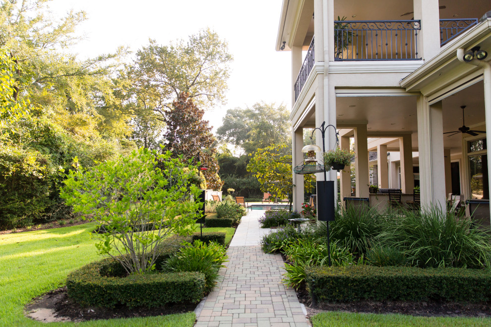 Design ideas for an expansive back formal partial sun garden in Houston with a garden path and brick paving.