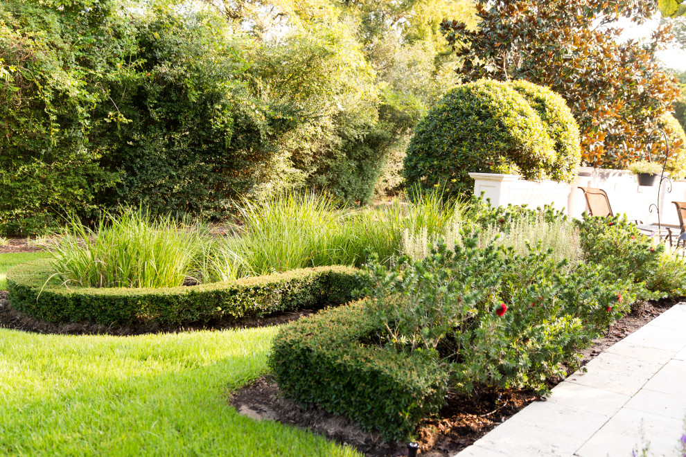На фото: огромный участок и сад на заднем дворе с полуденной тенью, клумбами и мощением клинкерной брусчаткой