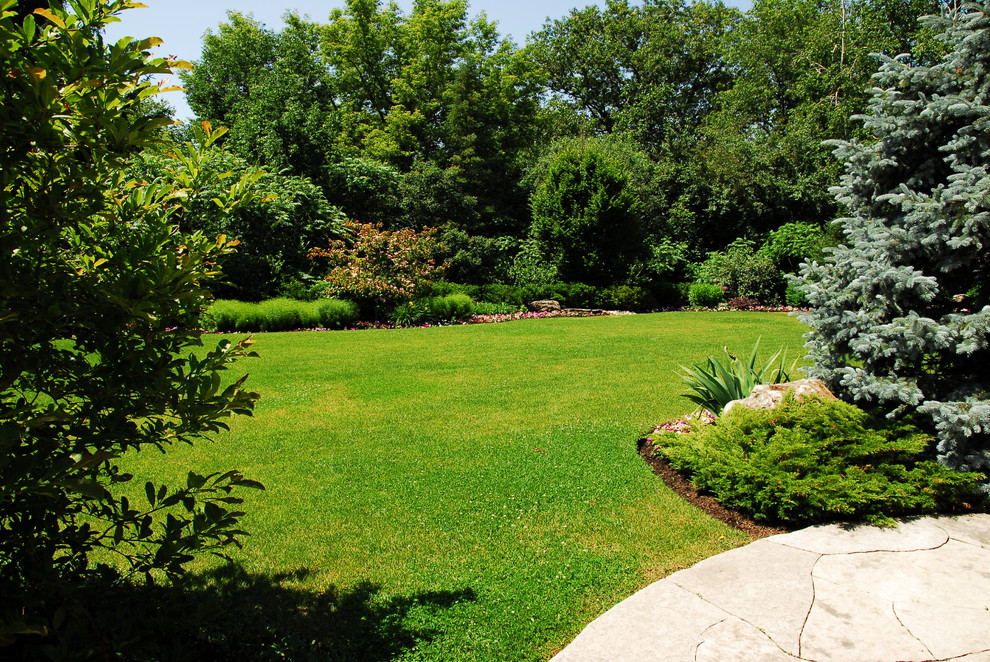 Foto di un grande orto in giardino tradizionale esposto a mezz'ombra dietro casa in primavera con pavimentazioni in pietra naturale