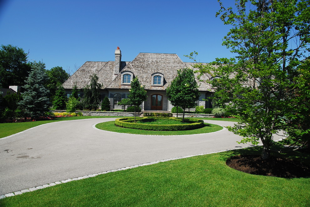 Inspiration for a large traditional partial sun front yard stone driveway in Toronto for spring.