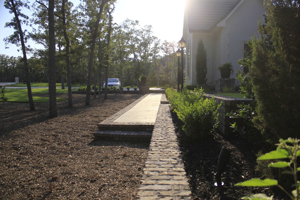 Пример оригинального дизайна: участок и сад на переднем дворе в классическом стиле с садовой дорожкой или калиткой и мощением тротуарной плиткой