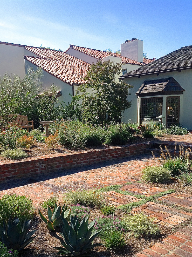 This is an example of a small bohemian front xeriscape full sun garden in Los Angeles with a garden path and brick paving.