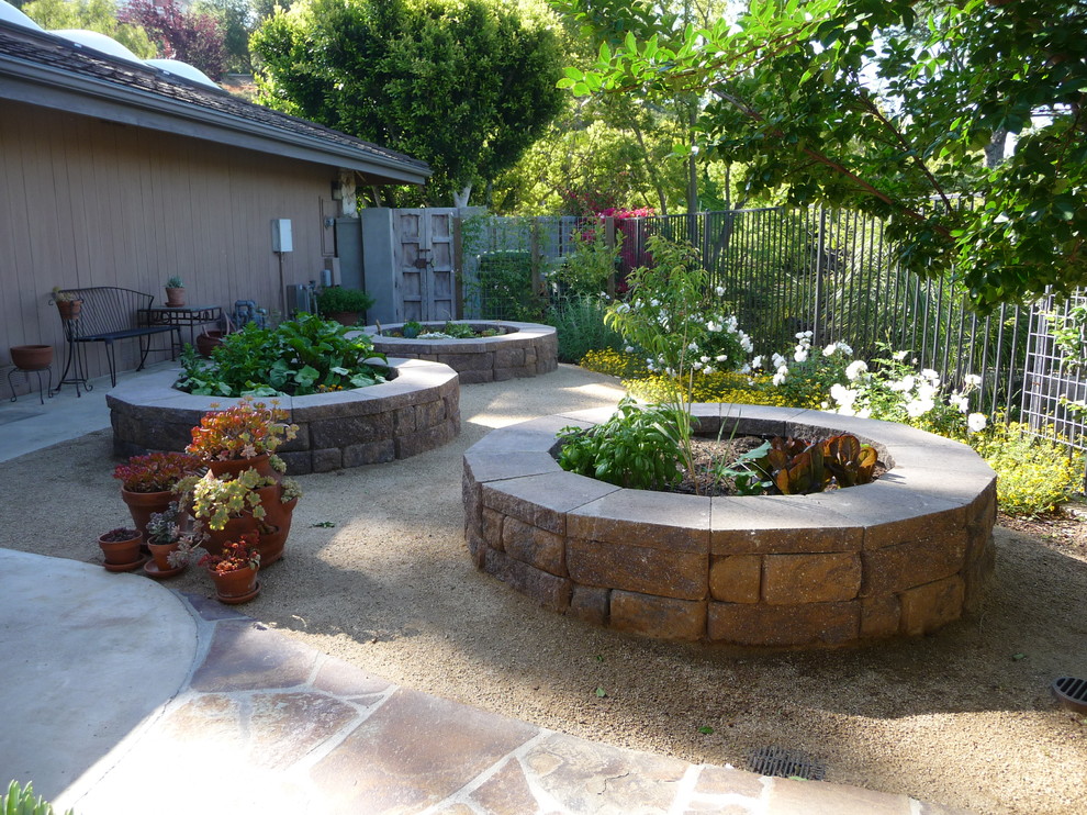 Design ideas for a medium sized traditional back xeriscape partial sun garden in Los Angeles with a potted garden and natural stone paving.