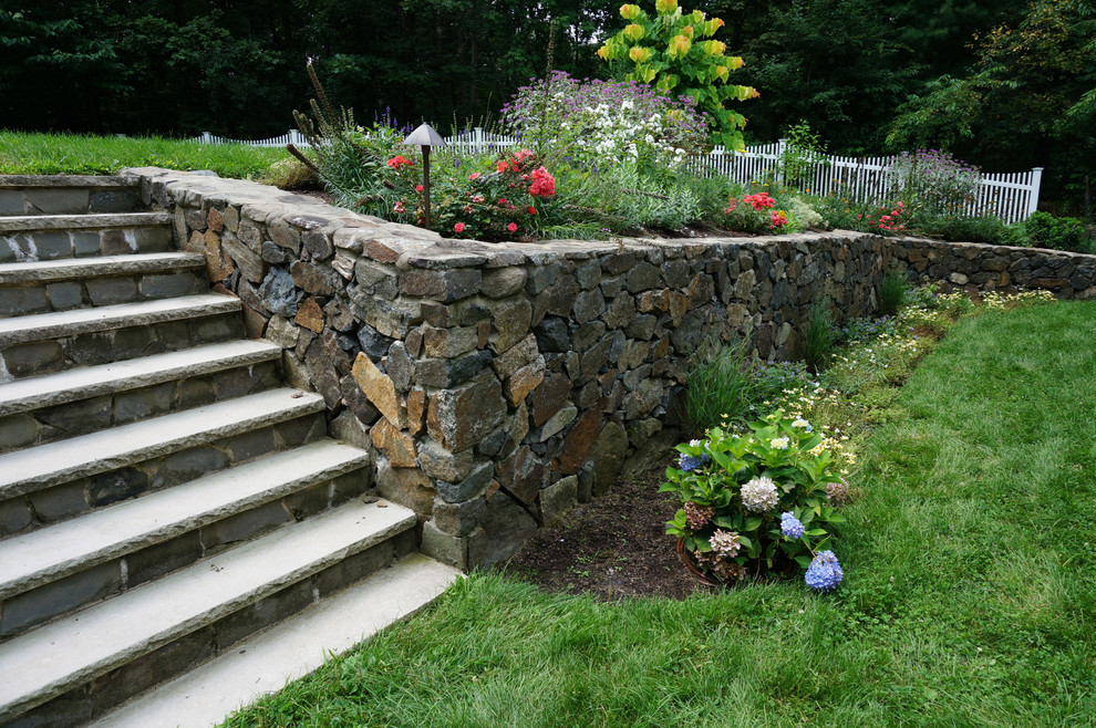 Photo of an expansive modern back formal partial sun garden in Boston with a retaining wall and natural stone paving.