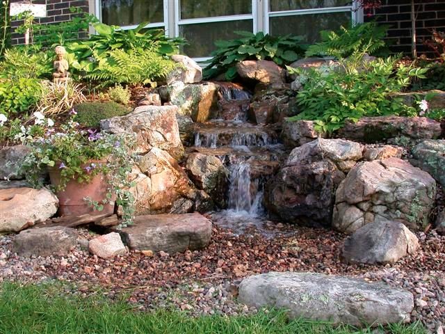 Esempio di un giardino formale american style esposto in pieno sole di medie dimensioni e dietro casa in primavera con fontane e pavimentazioni in pietra naturale