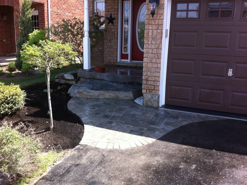 Photo of a small contemporary front partial sun garden for summer in Toronto with brick paving.