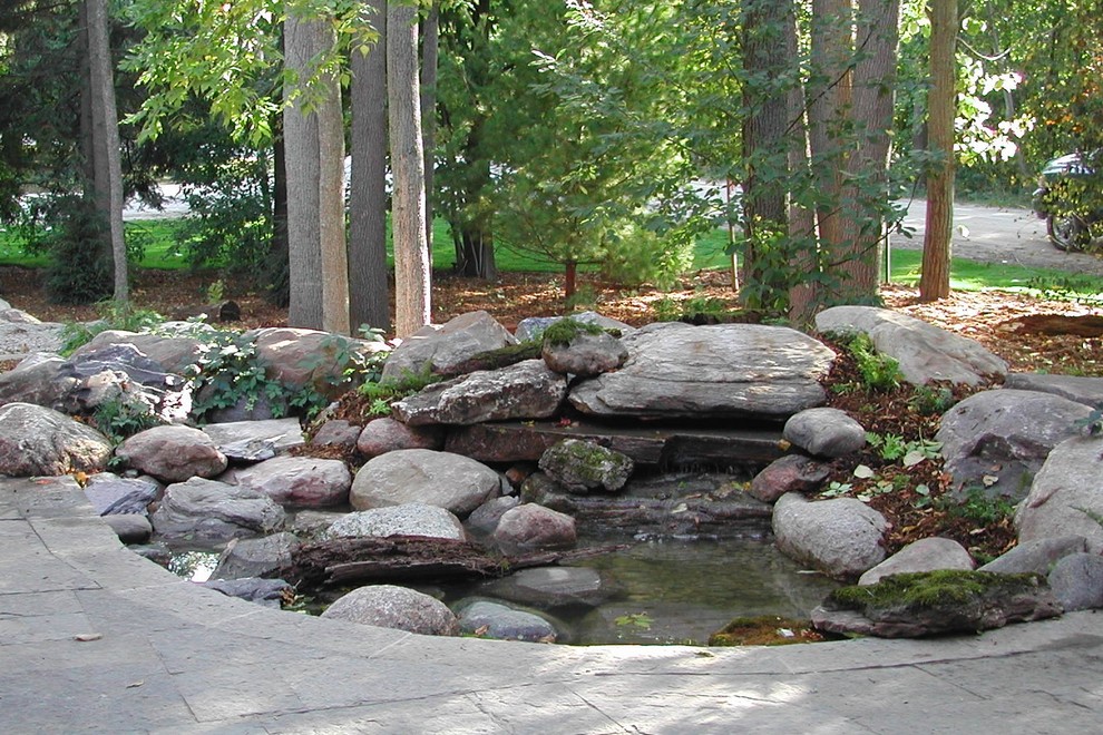 Photo of a medium sized contemporary back fully shaded garden in Toronto with a water feature and natural stone paving.