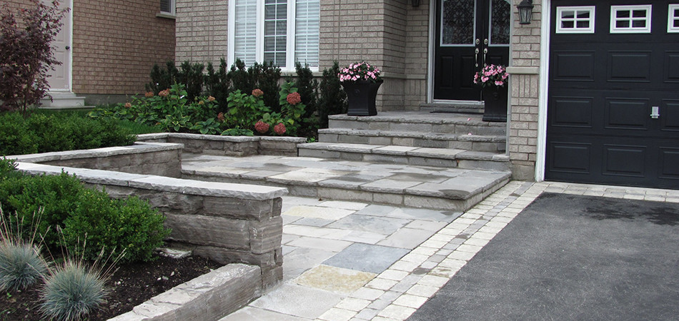 Photo of a large classic front partial sun garden in Toronto with natural stone paving.