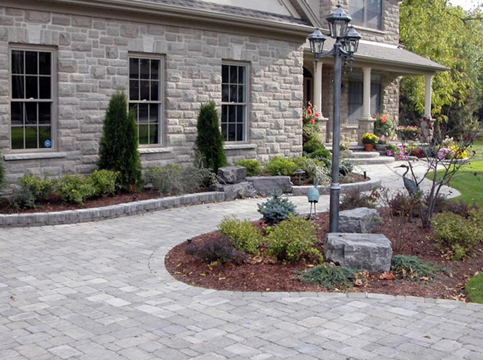 Design ideas for a mid-sized traditional full sun front yard stone driveway in Toronto.