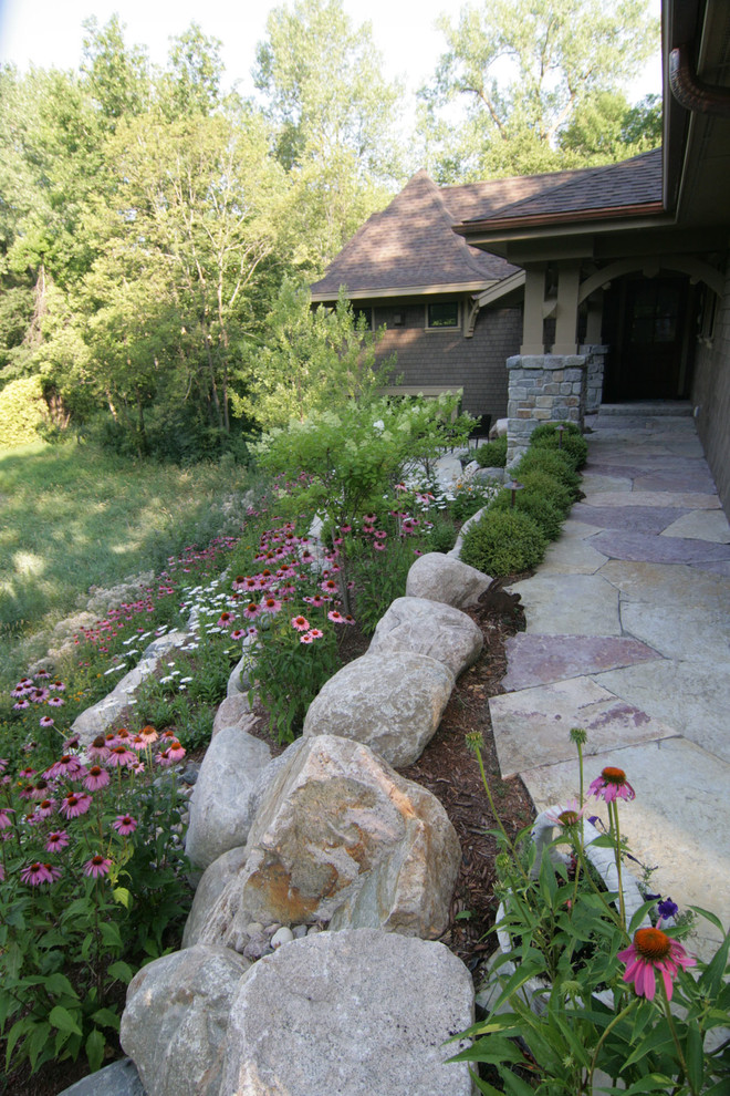 This is an example of a large craftsman partial sun front yard stone landscaping in Minneapolis.