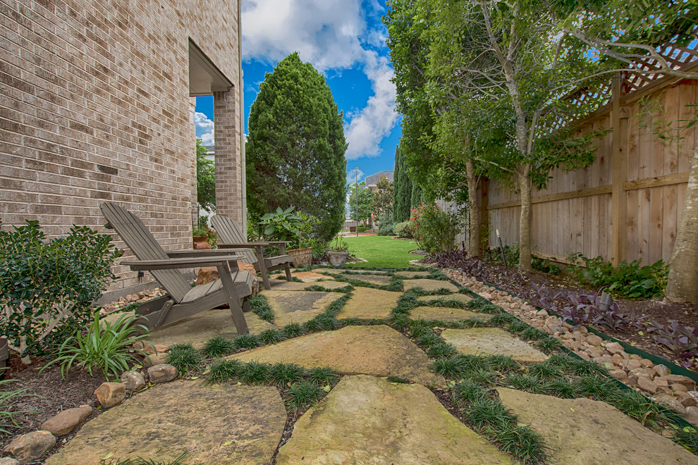 На фото: маленький летний регулярный сад на боковом дворе в классическом стиле с полуденной тенью и покрытием из каменной брусчатки для на участке и в саду с