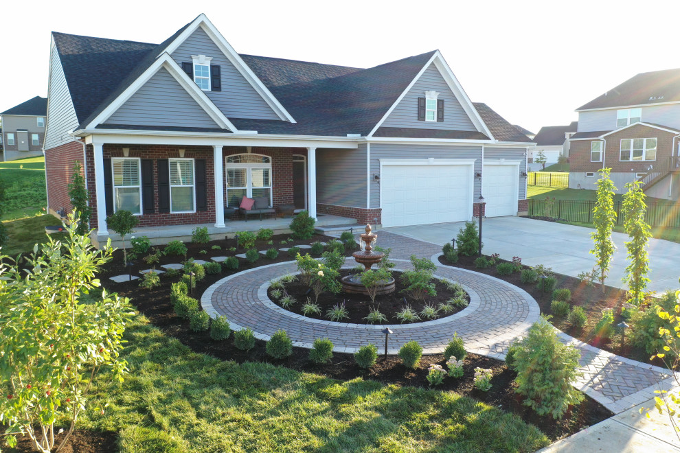 Photo of a mid-sized traditional partial sun front yard concrete paver landscaping in Other for summer.