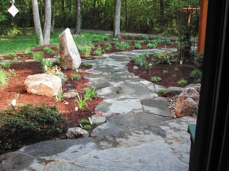 Small world-inspired front fully shaded garden for summer in Boston with a garden path and natural stone paving.