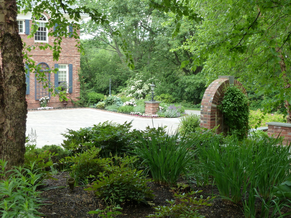 Großer, Halbschattiger Klassischer Vorgarten im Frühling mit Auffahrt und Natursteinplatten in Boston