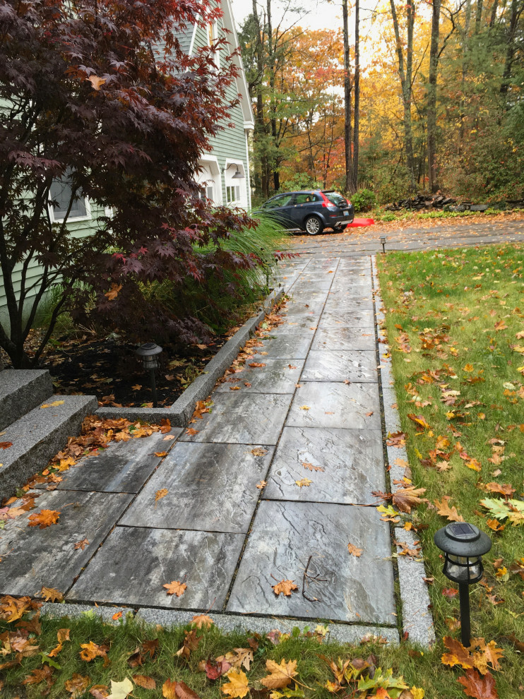 This is an example of a small front garden in Portland Maine with a pathway and concrete paving.